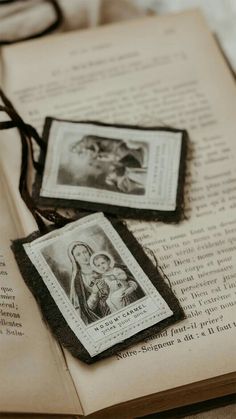 an open book with two small pictures on it and a string attached to the pages