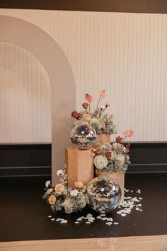 two vases with flowers are sitting on the floor next to boxes and confetti