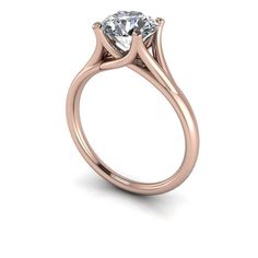 a rose gold engagement ring with a round cut diamond in the center, on a white background