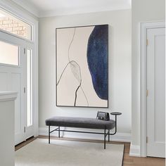 a painting hanging on the wall above a bench in front of a door and window