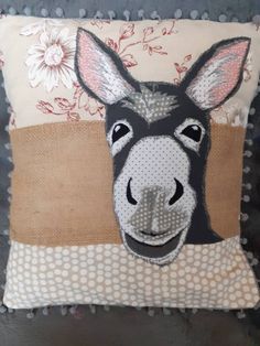 a decorative pillow with a donkey's head on it and polka dots around the edges