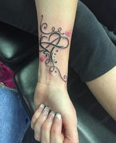 a woman's hand with a tattoo on her wrist and the word love written in it