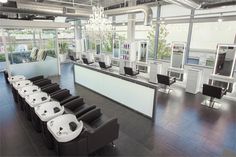 an empty salon with chairs and mirrors in the room, all lined up against the wall