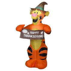 an inflatable winnie the pooh holding a happy thanksgiving sign