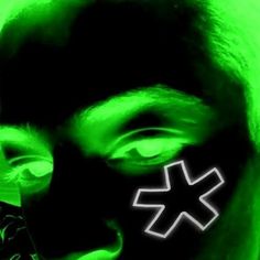 a man wearing a black mask with green light on his face and cross painted on it