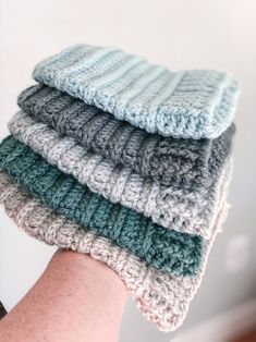 four crocheted dishcloths stacked on top of each other in different colors