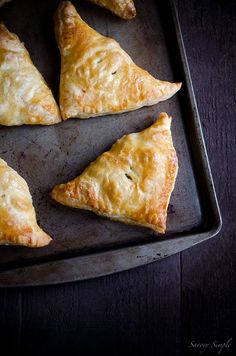 four pastries on a baking sheet ready to be baked in the oven for consumption