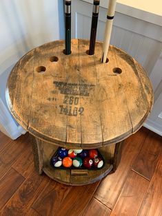 an old wooden table with pool balls and cues in it on the floor next to a door