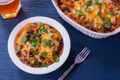 two white dishes filled with mexican food and garnished with cilantro