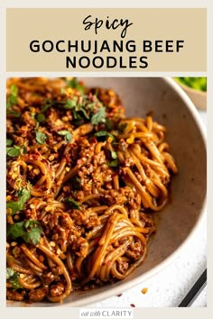 spicy gochuang beef noodles in a white bowl with chopsticks on the side