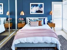 a bedroom with blue walls and white bedding