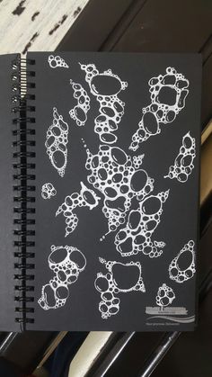 a notebook with black paper and white designs on it