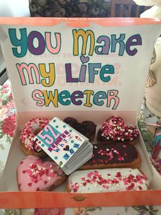 a box filled with lots of different types of doughnuts on top of a table