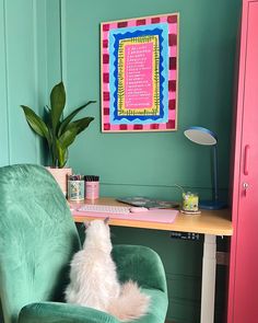 a white dog sitting in a green chair next to a desk