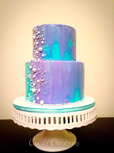 a blue and purple cake sitting on top of a white plate