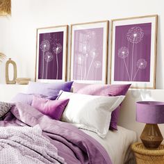 a bedroom with purple and white decor on the wall above the bed is decorated with three framed dandelions