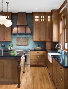 a large kitchen with wooden cabinets and stainless steel appliances, along with wood flooring