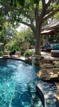 an outdoor swimming pool surrounded by trees and rocks