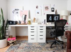 a home office with lots of clutter on top of the desk and chairs in front of it