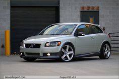 a silver volvo car parked in front of a building