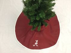 a potted plant sitting on top of a red cloth covered round tablecloth with the letter a