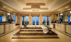 a large bathroom with two sinks, tub and chandelier in front of windows