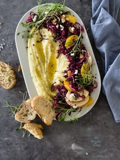 a white plate topped with food next to bread