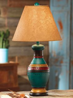 a lamp that is sitting on top of a table next to a potted plant