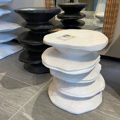 a stack of black and white stools sitting on top of a gray tile floor