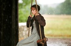 a woman sitting on a swing in the rain