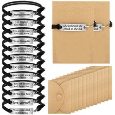 a bunch of black and silver bracelets on top of each other next to a brown envelope