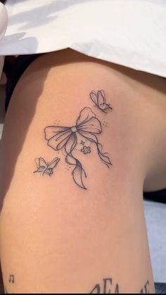 a woman's thigh with flowers and butterflies tattoo on her side ribcage