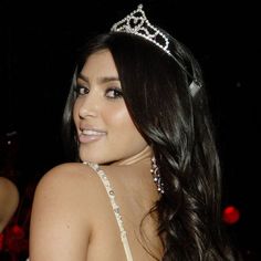 a woman wearing a tiara and smiling at the camera