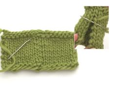 the knitting needle is being used to make a knitted stitch on a green piece of cloth