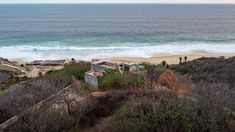 an aerial view of a beach with houses on it and the ocean in the background