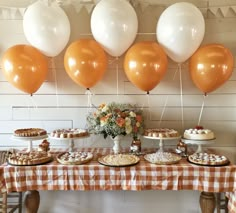 an assortment of desserts on a table with balloons