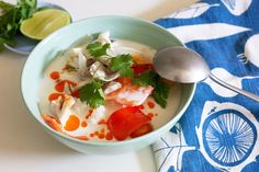 a bowl filled with soup and garnished with cilantro, tomatoes, and mushrooms