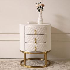 a white and gold cabinet with flowers on top