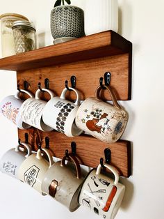 a wooden shelf holding coffee cups and mugs