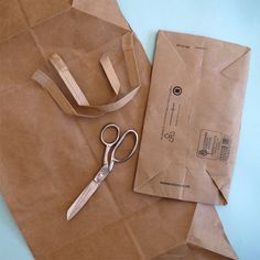 a pair of scissors sitting on top of a brown paper bag