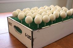 a box filled with golf balls on top of a wooden table