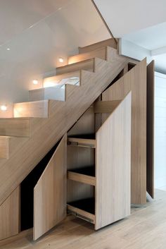 a wooden staircase with drawers underneath it