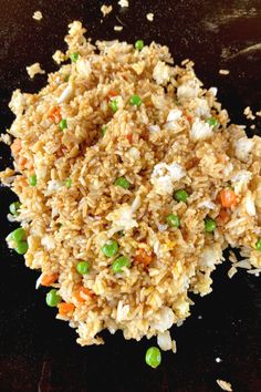 rice with peas and carrots on a black plate