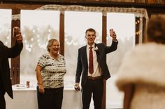 a man and woman standing next to each other in front of a table with people taking pictures