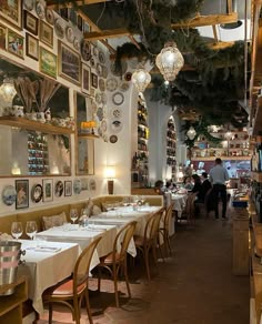 an empty restaurant with tables and chairs in front of the wall full of pictures on the walls