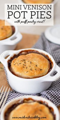 three small white dishes filled with pies on top of a wooden table next to silverware