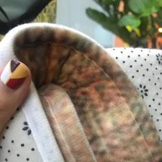 a woman's hand with a red, yellow and white manicure on it