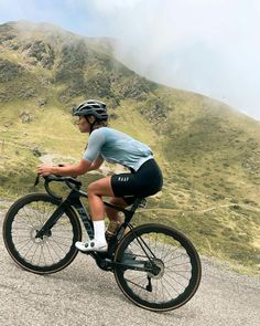 a man riding a bike on top of a gravel road