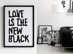 a black and white living room with art on the wall, love is the new black