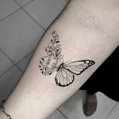 a black and white butterfly tattoo on the arm